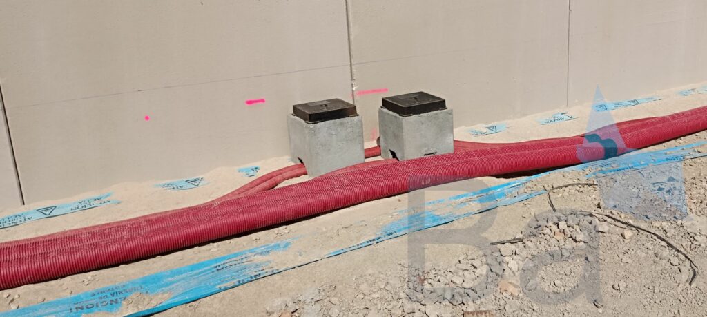 Electrical and telecommunications conduits laid on the ground.